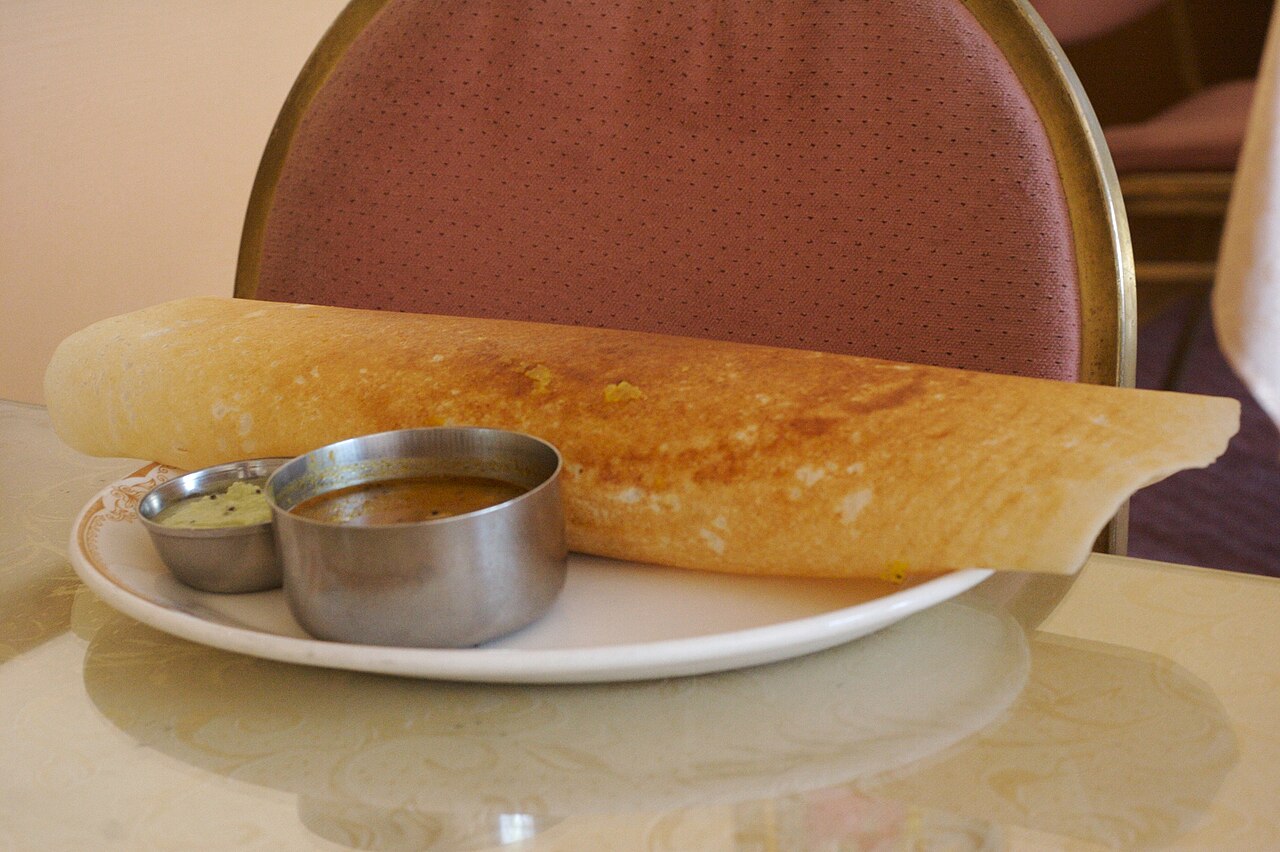 Dosa served with chutney and sambar.