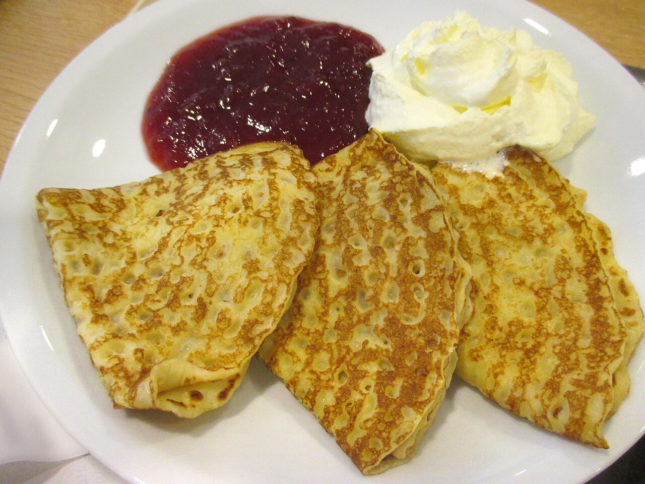 Swedish pancakes served with jam and whipped cream.